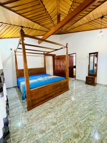 a bedroom with a wooden bed in a room at Gemlita Villa in Uswetakeiyawa in Bopitiya
