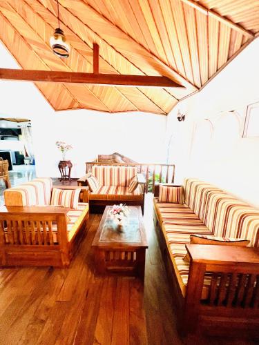 a living room with couches and a table at Gemlita Villa in Uswetakeiyawa in Bopitiya