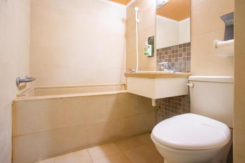 a bathroom with a toilet and a bath tub at Mei Jia Mei Hotel in Jiaoxi