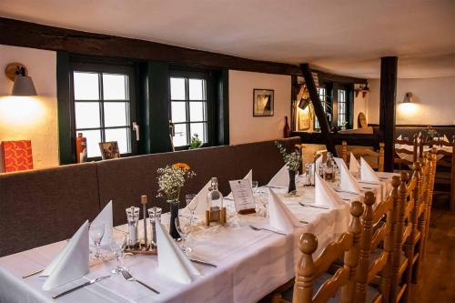 a table with white napkins on it in a restaurant at Pension Goldener Zwinger in Meiningen