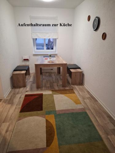 a room with a table and benches and a rug at FeWo s Runde Wiese WO in Greifswald