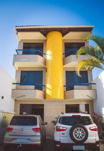two cars parked in front of a building at Pousada Raio do Sol in Ilhéus