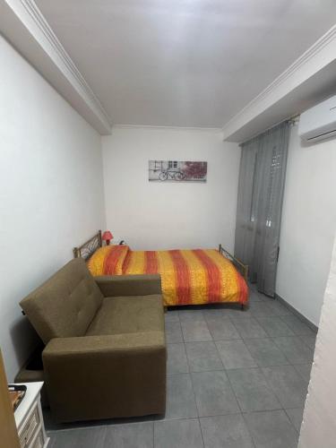 a bedroom with a bed and a couch in it at M&C Rooms di Claudia in Fiumicino