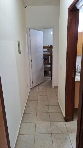 a hallway with a door and a tile floor at Casa mobiliada para até 14 pessoas in Ribeirão Preto