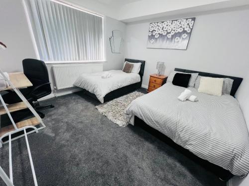 a bedroom with two beds and a desk at Cosy house Trafford Manchester in Manchester