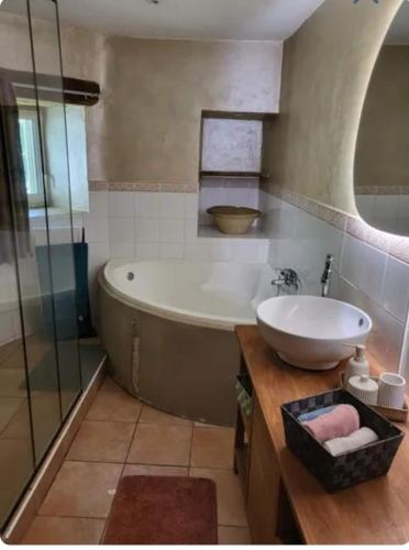 une salle de bain avec une baignoire et un lavabo dans l'établissement La Maison du chataignier, à Cassagnolles
