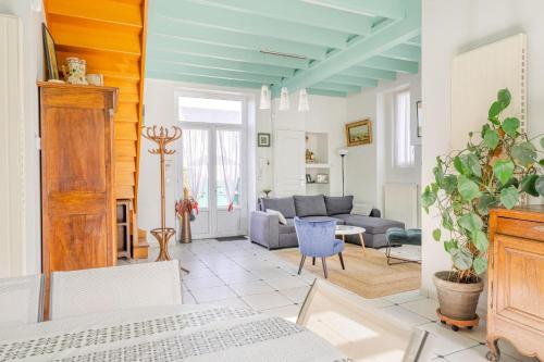 een woonkamer met een bank en een tafel bij L'Embrun - T5 - Wifi - Accès à la mer in La Bernerie-en-Retz