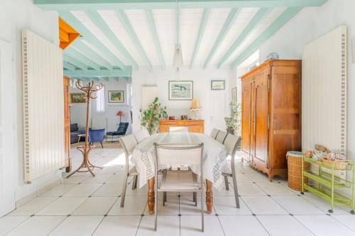 een eetkamer met een tafel en stoelen bij L'Embrun - T5 - Wifi - Accès à la mer in La Bernerie-en-Retz