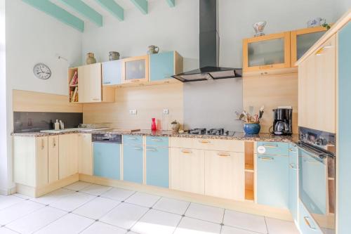 - une cuisine avec des placards en bois et des appareils bleus dans l'établissement L'Embrun - T5 - Wifi - Accès à la mer, à La Bernerie-en-Retz
