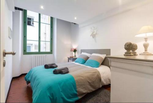 une chambre avec un grand lit avec des draps bleus dans l'établissement Authentique 2 pièce dans le Vieux-Nice, à Nice