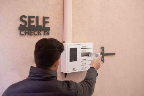 a man is putting a key into a microwave at Concilium in Trento