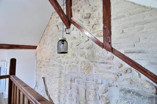 un mur de pierre avec une lumière suspendue dans l'établissement Duplex rénové - Proche centre-ville, à Bourges