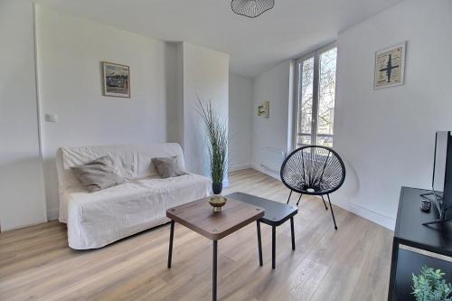 un salon avec un canapé blanc et une table dans l'établissement Duplex rénové - Proche centre-ville, à Bourges