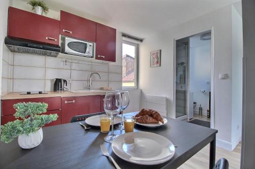 une cuisine avec une table et des verres à vin dans l'établissement Duplex rénové - Proche centre-ville, à Bourges
