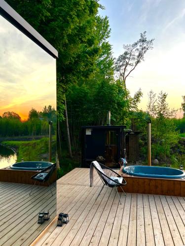 a hot tub sitting on a deck next to at Mimpi Experience Peegelmajad in Assikvere