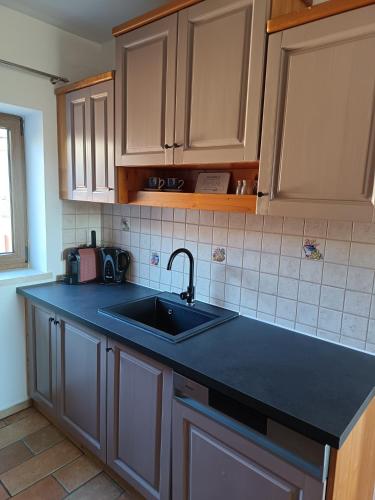 a kitchen with a sink and a black counter top at Natur Erlebnishof Aumayr in Gutau