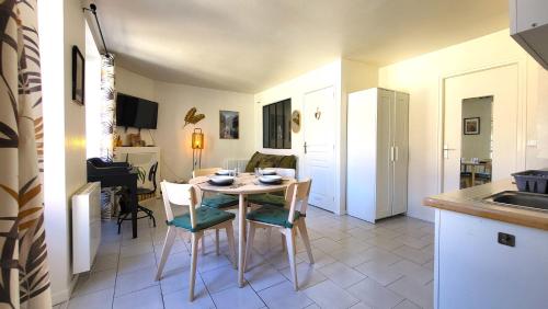 une cuisine et une salle à manger avec une table et des chaises dans l'établissement Le Paradis - Charmants appartements proche nature, à Verrières-le-Buisson