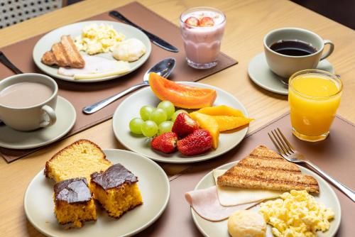 a table topped with plates of breakfast foods and drinks at Pousada Cachoeira da Barra in Cunha