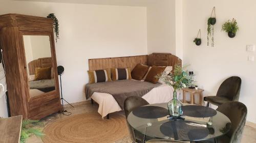 une chambre avec un lit, une table et un miroir dans l'établissement Gîte de Pied Chapel - Piscine, spa et pleine nature, à Alba-la-Romaine