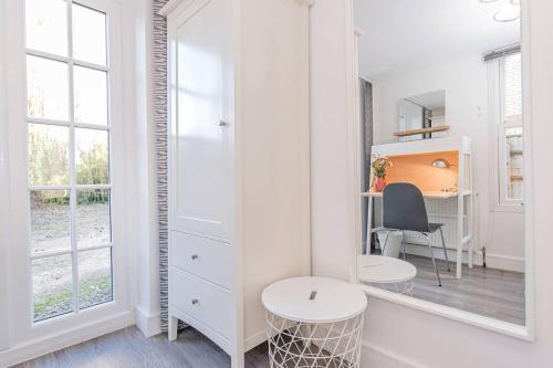 a white room with a desk and a mirror at Flat 3, 158 Abingdon Road in Oxford