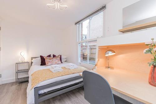 a bedroom with a bed and a desk and a window at Flat 3, 158 Abingdon Road in Oxford