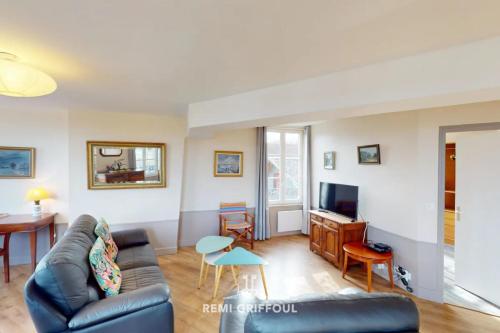 un salon avec un canapé et une télévision dans l'établissement Duplex Traversière Spacious 100m from the Port 4 Guests, à Honfleur