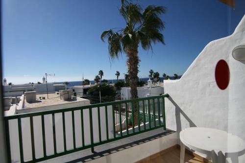 a balcony with a table and a palm tree at Apartamentos Guanarama in Puerto del Carmen