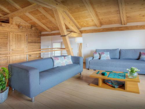 un salon avec deux canapés bleus et une table dans l'établissement Chalet Arsene et Lea - OVO Network, à Manigod