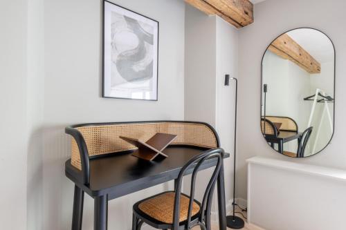 a black table and chair in a room with a mirror at Stylish loft in the heart of CPH in Copenhagen