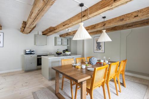 a kitchen and dining room with a wooden table and chairs at Stylish loft in the heart of CPH in Copenhagen