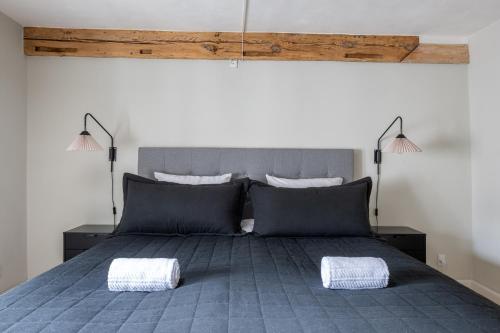 a bedroom with a blue bed with two pillows at Stylish loft in the heart of CPH in Copenhagen