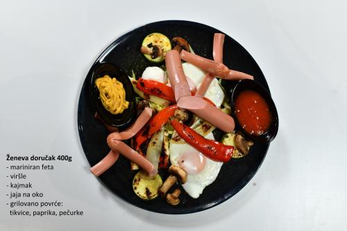 a black plate of food with vegetables on it at Hotel Ženeva Lux in Kragujevac