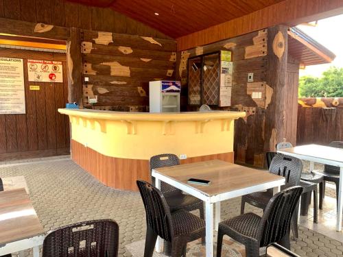 a restaurant with a counter and tables and chairs at F1 Green Meadows Resort in Arnedo