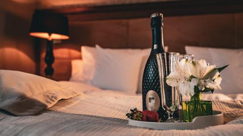 a bottle of wine and flowers on a bed at Hotel & Medi-Spa Biały Kamień in Świeradów-Zdrój