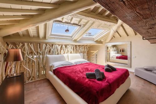 a bedroom with a large bed with a red blanket at GOLDEN LUXE - Botero Loft Design Penthouse in Pietrasanta