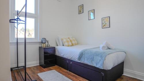 a bedroom with a bed and a window at Spacious Bromley Home w Free parking and Outside Dining in Bromley