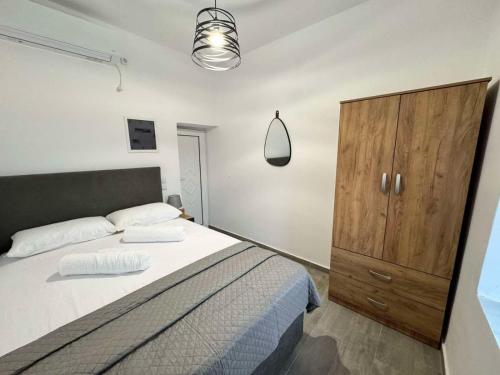 a bedroom with a large bed and a wooden cabinet at Amalour Villa in Amálon