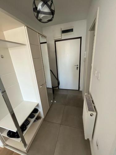 a walk in closet with a door in a room at Chromatic Apartment in Sarajevo