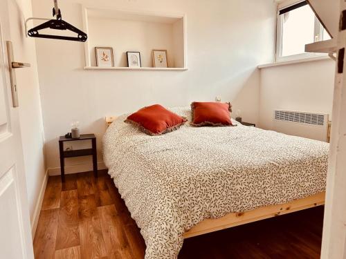 une chambre avec un lit avec deux oreillers dessus dans l'établissement Le Carnot Perche, à Le Portel