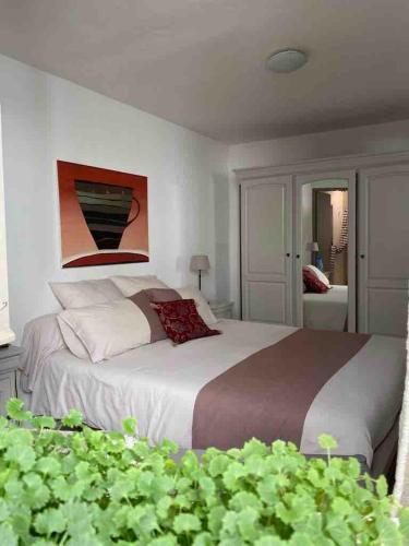 une chambre avec un grand lit avec un tableau au mur dans l'établissement Appartement de charme au pied du château, à Châteaurenard