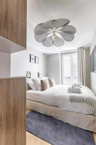 une chambre avec un grand lit avec un ventilateur de plafond dans l'établissement Mykeypers - Magnificent Luxury Flat 2BR-6P - Champ-Elysées, à Paris