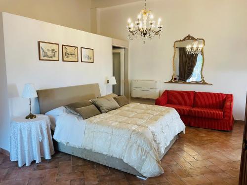 a bedroom with a bed and a red chair at Agriturismo Eco-Bio Villa Vacasio in Pitigliano