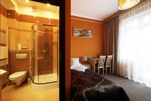 a hotel room with a shower and a bathroom at Willa San Remo in Kudowa-Zdrój