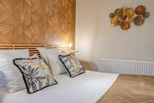 a bed with two pillows and a wooden headboard at Les gîtes de la vallée du rivoal in Lopérec