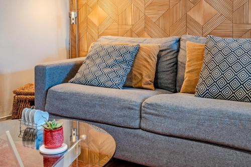 a couch with pillows and a table in a living room at Les gîtes de la vallée du rivoal in Lopérec