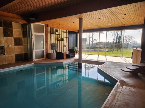 - une piscine dans une maison avec une grande fenêtre dans l'établissement La Villa de Louis, à Saint-Planchers