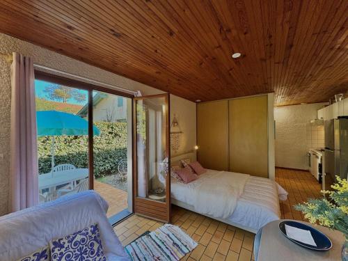 - une chambre avec un lit et une terrasse avec un parasol dans l'établissement Kakatoès - Studio à 500m des plages, à Mimizan-Plage
