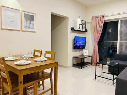 辛加瓦迪CyberNest Spacious APT in IT hub Hinjewadi的用餐室以及带桌子和电视的客厅。