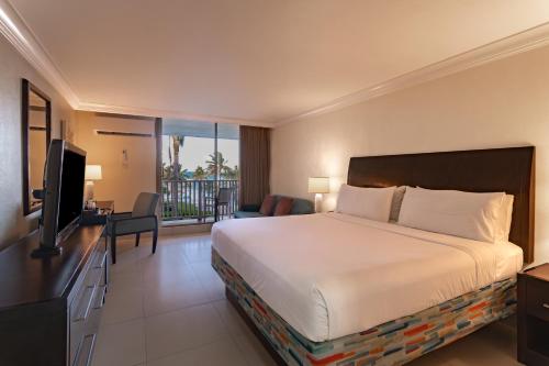 a hotel room with a bed and a television at Catalonia Montego Bay - All Inclusive in Montego Bay