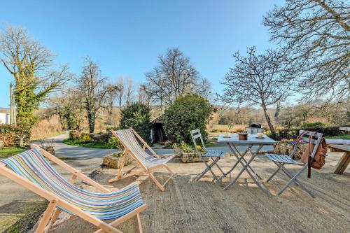 a group of chairs and a table in a yard at Les gîtes de la vallée du rivoal in Lopérec